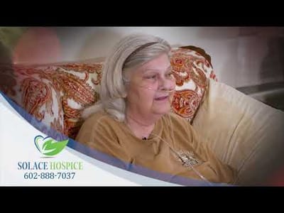 Resident of Solace Hospice smiling in a cozy setting.