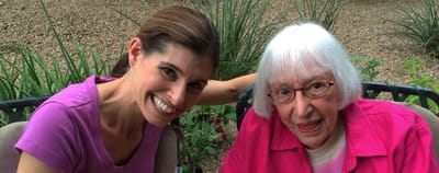 A caregiver with a senior resident outdoors.