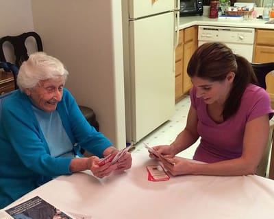Two women engaging in a card game indoors.