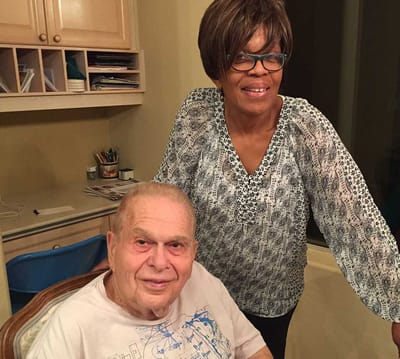 Senior resident and caregiver interacting indoors