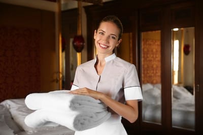 Staff member smiling while holding towels.