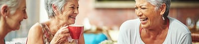 Three women enjoying tea and laughter together