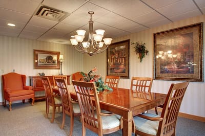 Elegant dining room with a large wooden table and artwork.