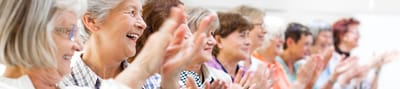 Group of smiling senior women clapping together