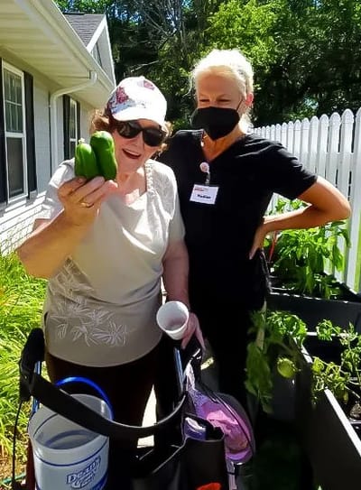 Resident interacting with staff in a garden