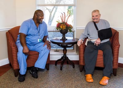 Staff member and resident engaging in a cozy common area.