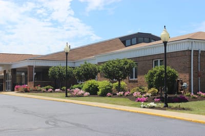 Exterior view with flowers and landscaping.