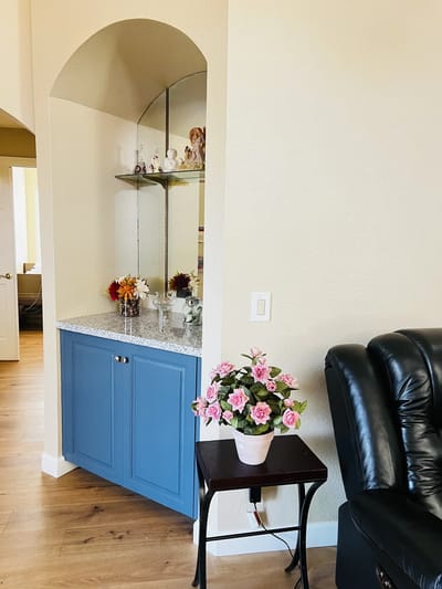 Decorative interior corner with flowers and a shelf.