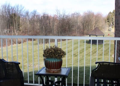 View from a balcony featuring a pot and grassy area.