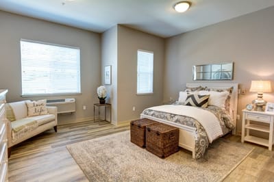 A cozy private resident room with a bed and seating area