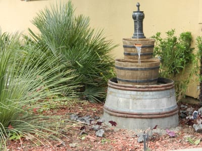 Outdoor water fountain surrounded by plants