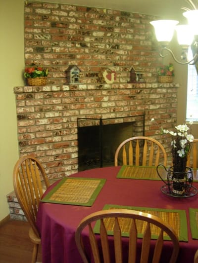 Dining area with a round table and brick fireplace