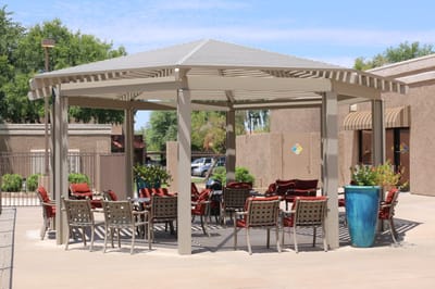 Outdoor shaded seating area with tables and chairs