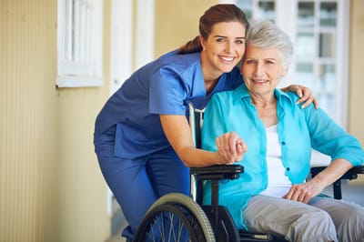 A caregiver assisting an elderly resident in a wheelchair