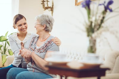 Caregiver interacting with a senior resident in a cozy interior