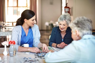 Residents and staff engaging in a puzzle activity indoors