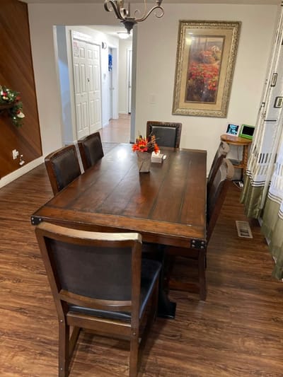 A dining room table set with chairs in an interior space.