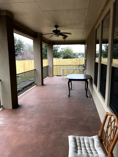Covered porch area with a table and seating