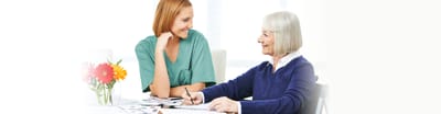 A caregiver and resident engaged in an activity together