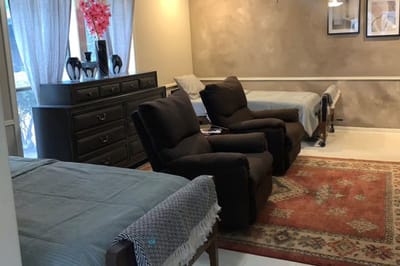 Brightly lit interior of a shared resident room with beds