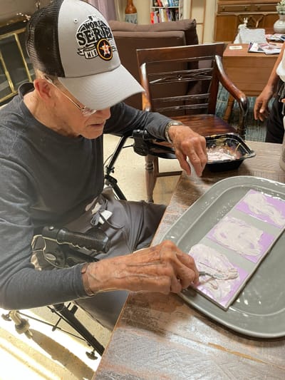 Resident engaged in an art activity at a table