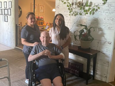 Resident with staff members in a cozy common area