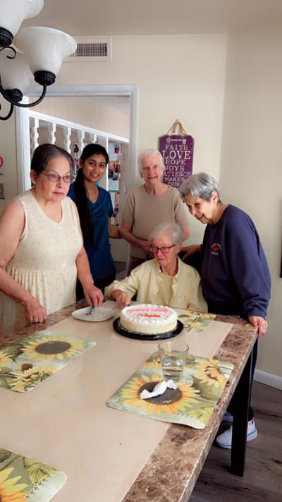 Residents celebrating with a cake in a communal area.