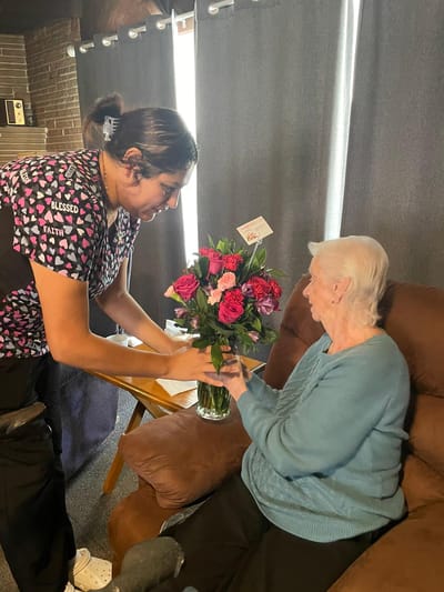Staff member presenting flowers to a resident
