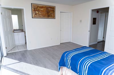 Empty bedroom with blue bedspread and artwork