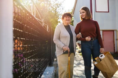 Resident walking with staff in outdoor path