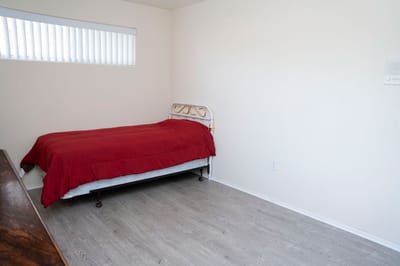 Minimalist bedroom with a red blanket on the bed