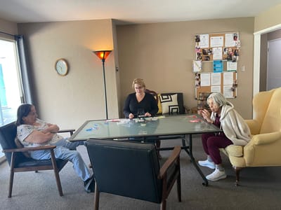 Residents and staff engaged in conversation at a table.