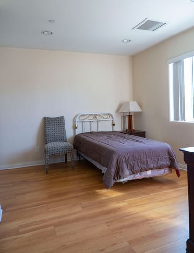 Simple bedroom with a bed and a chair