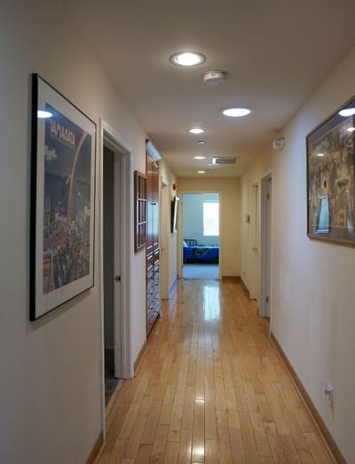 Well-lit hallway with wooden flooring.