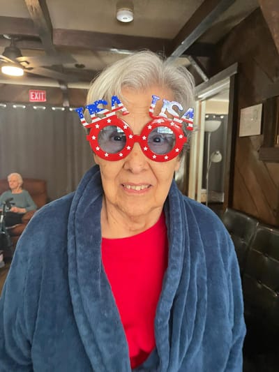 Smiling resident wearing festive USA-themed glasses