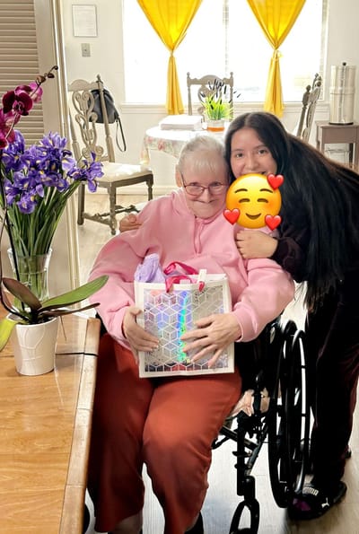 A resident and staff member celebrating with a gift