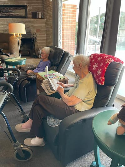 Two elderly women reading in comfortable chairs