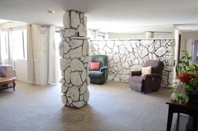 Common area with seating and stone wall.