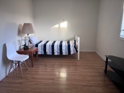 Single bed room with lamp and chair