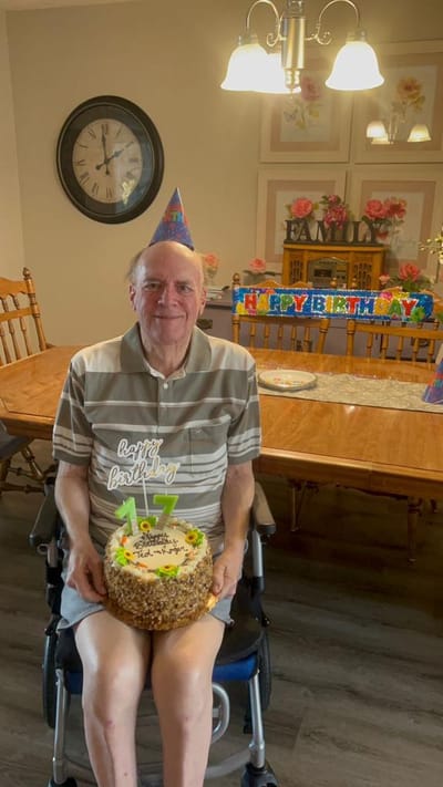 Resident celebrating birthday with cake and decorations.