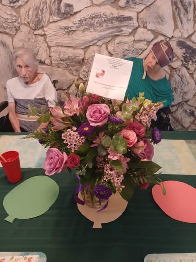 Residents enjoying a floral arrangement during an event.