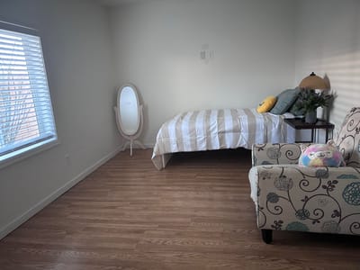 Cozy resident room with bed and seating area.