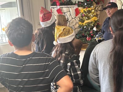 Residents celebrating with festive hats in a common area.