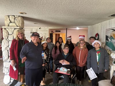 Residents and staff in a festive indoor setting.