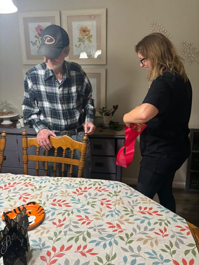 A resident interacts with staff in a dining area.