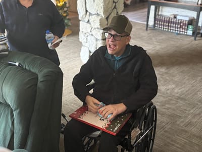 Resident in a wheelchair enjoying the common area.