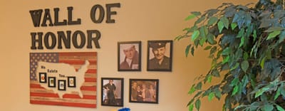 Wall of honor displaying framed photographs and decor