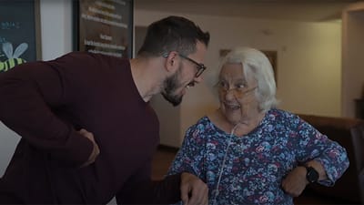 A staff member interacting with a smiling resident