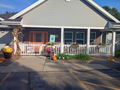 Front porch of Sienna Crest Assisted Living decorated with flowers and pumpkins