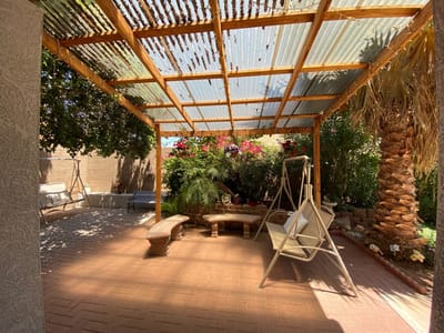 A shaded outdoor seating area surrounded by flowers